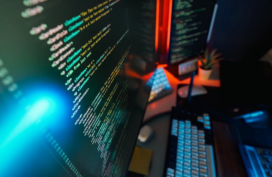 The image depicts a close-up of a smartphone screen displaying lines of colorful programming code on a dark background. The phone is held at an angle, with the edges slightly visible, and the text inc